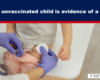 Healthcare worker in purple gloves gives a child a shot in the thigh while the child sits on a table; banner above reads 'Every unvaccinated child is evidence of a crime'.