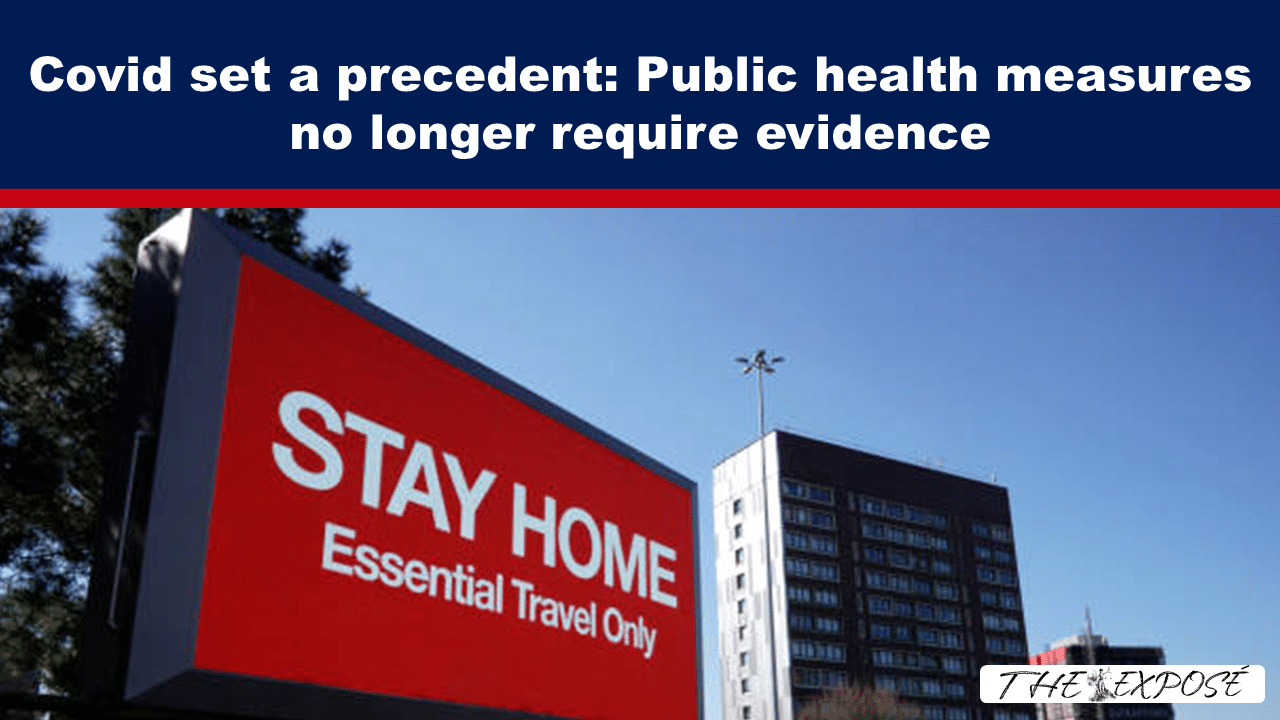 City scene with a large red 'STAY HOME' billboard reading 'Essential Travel Only' under a blue header about Covid measures.