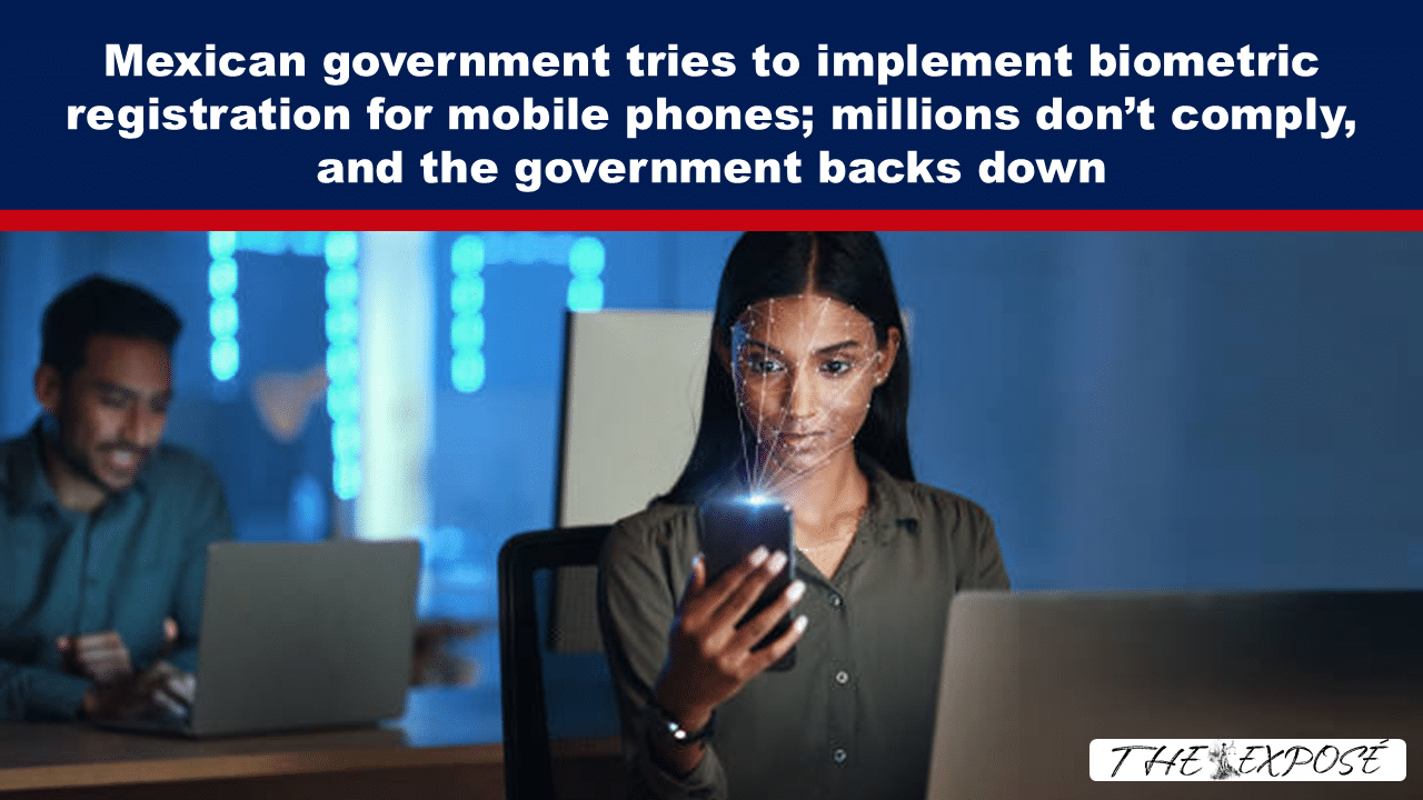 News article header about biometric registration; woman in a tech office looks at her smartphone with a man at a laptop in the background.