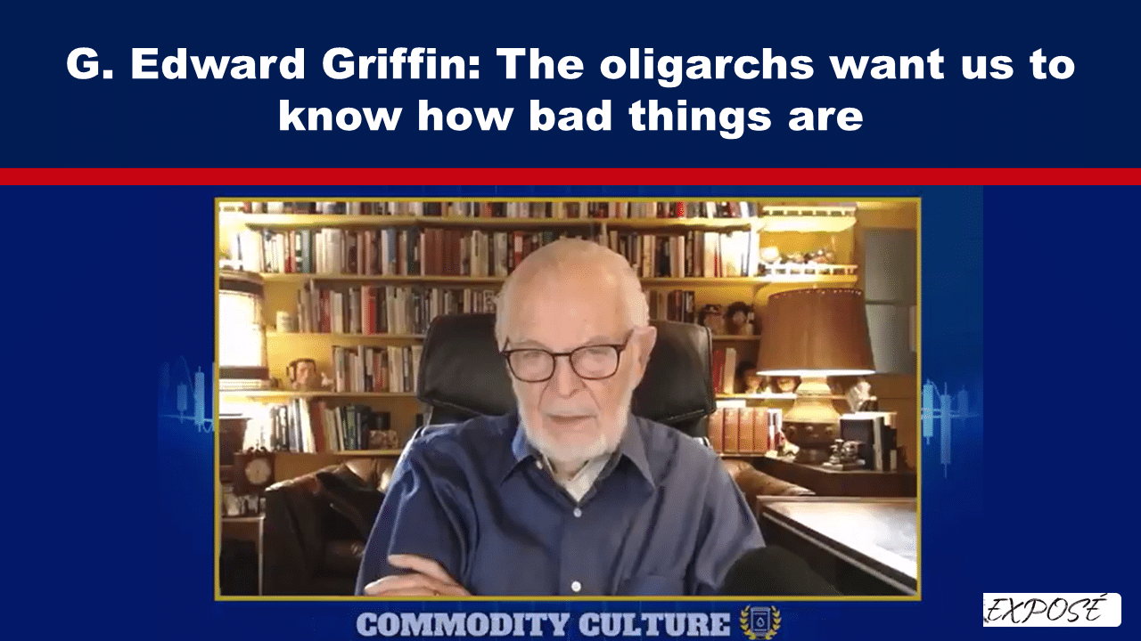 Video interview with an elderly man in glasses speaking, seated in a study with a bookshelf background and a blue broadcast banner reading 'G. Edward Griffin: The oligarchs want us to know how bad things are'.